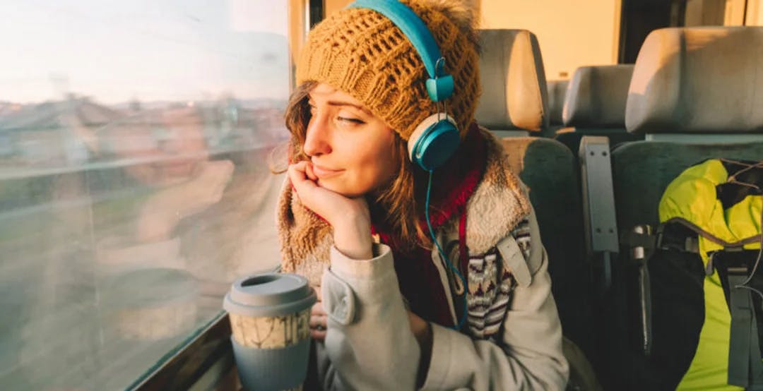 Kvinne på toget lytter til lydbok