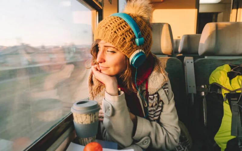 Kvinne på toget lytter til lydbok