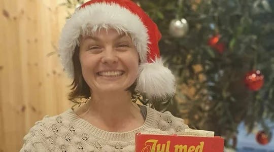 Bilde av Mari Nymoen med boka "Jul med Prøysen"