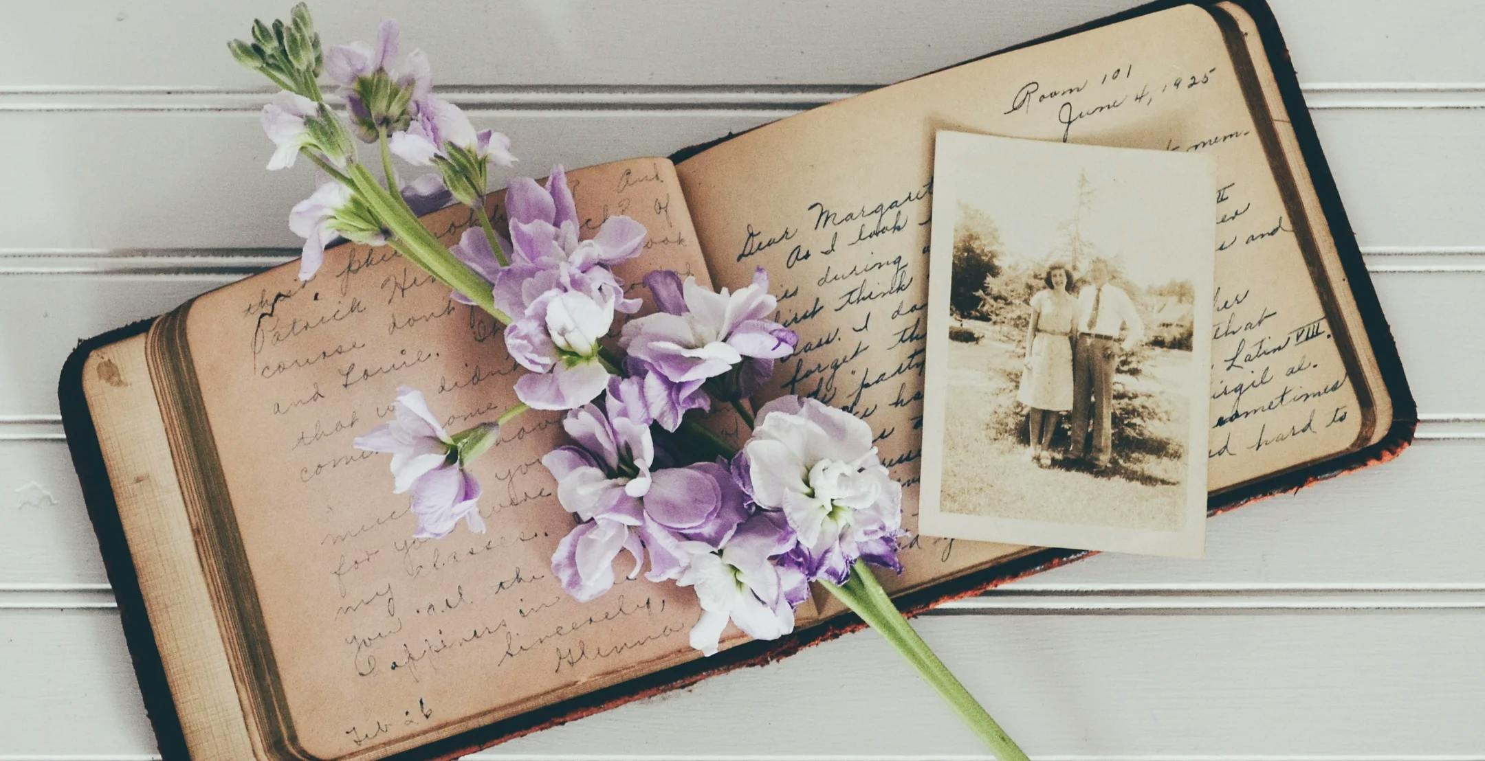 Gammel dagbok, gammelt bilde og en blomsterstilk
